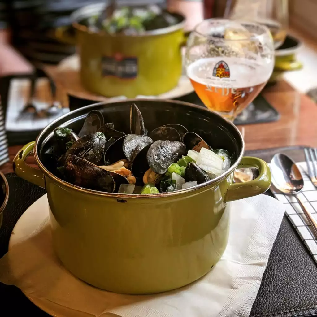 Eating mussels with a Belgian beer (c) Photo by Alana Harris on Unsplash